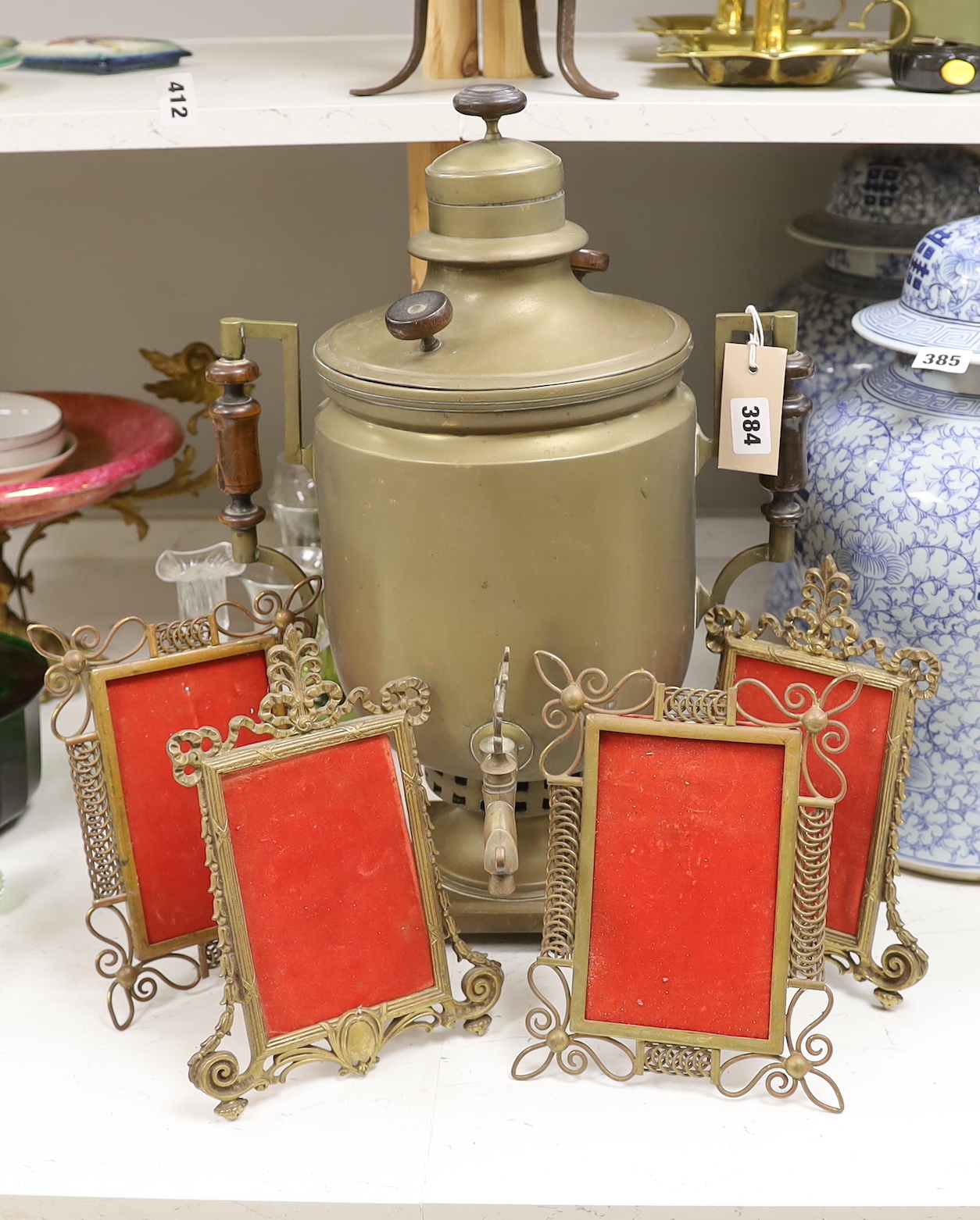 A brass tea urn and two pairs of brass photo frames, tallest 50cm